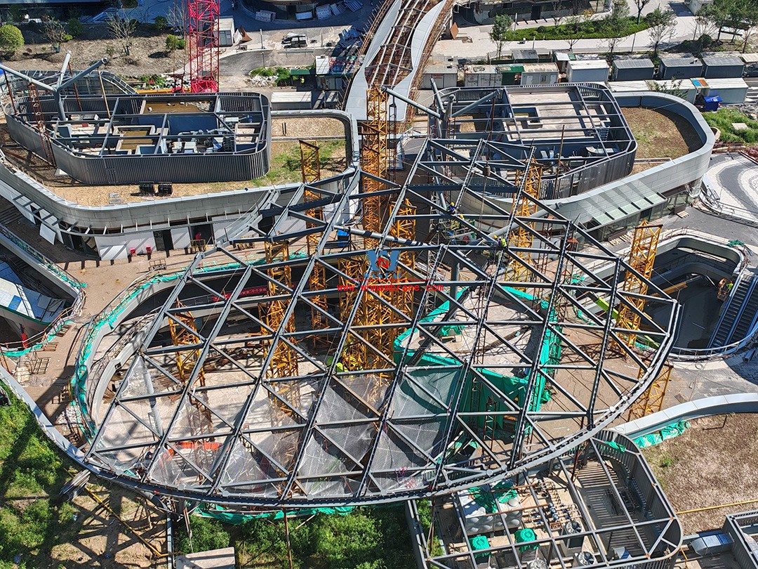 Recently, Shaoxing Huafa Financial Vitality City ETFE membrane structure commercial canopy ushered in new progress.  Shaoxing Huafa Financial Vitality City is located in Jinghu New District, Yuecheng District, Shaoxing City, 7.5km away from Shaoxing City Center, east to Xingzhong Road, west to Wenxian Road, south to Qunxian Road, north to Kwun Tong Road West. Huafa Financial Vitality City is the first commercial flagship brand of Guomai Huafa into Zhejiang, based on the history and future of Shaoxing, located in Jinghu high-end core, to create a construction surface of about 70,000 square meters of MALL BLOCK commercial street combination of urban creative consumption space. The vertical support system of the main steel structure of the canopy is a tree structure, the horizontal support system is a double-curved box lattice shell structure, and the steel columns and diagonal braces are all hoisted in a single hoisting mode. The roof lattice shell is assembled in blocks by automobile crane on the ground, and the crawler crane is hoisted in blocks. Finally, it is covered with ETFE film (soft glass). Make the whole commercial street more transparent and bright, dazzling.   The steel structure installation and splicing work is being carried out at the site. Due to the narrow space, the steel structure hoisting operation radius is large, and the on-site welding amount is large, and the recent attacks of high temperature and heavy rain have brought many tests to the project. According to the actual working conditions on the site, Marriott disassembled the steel structure hoisting section and calculated the hoisting equipment; And according to the actual situation of the project to organize relevant technical personnel to carry out targeted learning and understanding, multiple training. Establish BIM model to guide factory processing and on-site installation, adopt high-precision laser cutting, organize processing personnel and construction personnel to disclose information in special meetings, fully understand drawings and models, and provide a strong guarantee for project construction. Engineering quality is the control focus of each project, and this project is included in the company's key control projects. Throughout the construction process of the project, Marriott has always focused on this quality goal, increased human and material input, strengthened management, carried forward the company's key projects, and done a good job in the spirit of each project, implementing quality target management. In order to achieve the goal, Marriott has implemented the target value to each team according to the project, the responsibility to the person, and the site construction is meticulous. In order to ensure the smooth progress of the project, the construction staff of Marriott planned for the rainy day, inverted the schedule, thorough deployment, coordinated the allocation of resources from various parties, coordinated the allocation of personnel, materials and machines, communicated the operation technology and safety technology of the operation team in advance, and assembled, tested, accepted and obtained evidence of the steel structure mesh shell. During the construction process, in the face of hot and rainy summer weather, the engineering Department does a good job of heat prevention and flood control measures to ensure the safety of construction personnel, and fully promote the construction progress, all the construction personnel fight sunny days, grab rainy days, under the premise of ensuring safety and quality, and constantly promote the progress of steel structure assembly, creating conditions for the installation of membrane structure in the later period.   The smooth progress of the project laid a solid foundation for the completion of the 