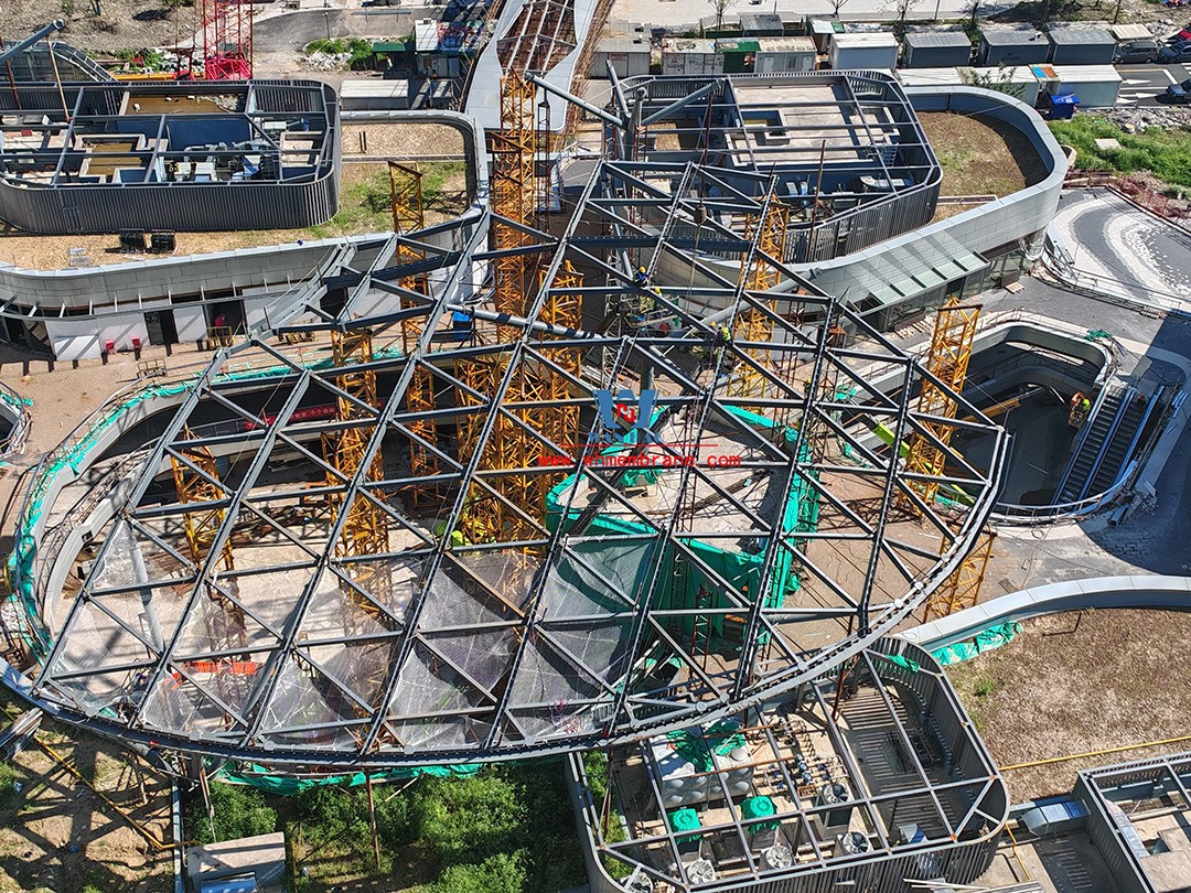 Recently, Shaoxing Huafa Financial Vitality City ETFE membrane structure commercial canopy ushered in new progress.  Shaoxing Huafa Financial Vitality City is located in Jinghu New District, Yuecheng District, Shaoxing City, 7.5km away from Shaoxing City Center, east to Xingzhong Road, west to Wenxian Road, south to Qunxian Road, north to Kwun Tong Road West. Huafa Financial Vitality City is the first commercial flagship brand of Guomai Huafa into Zhejiang, based on the history and future of Shaoxing, located in Jinghu high-end core, to create a construction surface of about 70,000 square meters of MALL BLOCK commercial street combination of urban creative consumption space. The vertical support system of the main steel structure of the canopy is a tree structure, the horizontal support system is a double-curved box lattice shell structure, and the steel columns and diagonal braces are all hoisted in a single hoisting mode. The roof lattice shell is assembled in blocks by automobile crane on the ground, and the crawler crane is hoisted in blocks. Finally, it is covered with ETFE film (soft glass). Make the whole commercial street more transparent and bright, dazzling.   The steel structure installation and splicing work is being carried out at the site. Due to the narrow space, the steel structure hoisting operation radius is large, and the on-site welding amount is large, and the recent attacks of high temperature and heavy rain have brought many tests to the project. According to the actual working conditions on the site, Marriott disassembled the steel structure hoisting section and calculated the hoisting equipment; And according to the actual situation of the project to organize relevant technical personnel to carry out targeted learning and understanding, multiple training. Establish BIM model to guide factory processing and on-site installation, adopt high-precision laser cutting, organize processing personnel and construction personnel to disclose information in special meetings, fully understand drawings and models, and provide a strong guarantee for project construction. Engineering quality is the control focus of each project, and this project is included in the company's key control projects. Throughout the construction process of the project, Marriott has always focused on this quality goal, increased human and material input, strengthened management, carried forward the company's key projects, and done a good job in the spirit of each project, implementing quality target management. In order to achieve the goal, Marriott has implemented the target value to each team according to the project, the responsibility to the person, and the site construction is meticulous. In order to ensure the smooth progress of the project, the construction staff of Marriott planned for the rainy day, inverted the schedule, thorough deployment, coordinated the allocation of resources from various parties, coordinated the allocation of personnel, materials and machines, communicated the operation technology and safety technology of the operation team in advance, and assembled, tested, accepted and obtained evidence of the steel structure mesh shell. During the construction process, in the face of hot and rainy summer weather, the engineering Department does a good job of heat prevention and flood control measures to ensure the safety of construction personnel, and fully promote the construction progress, all the construction personnel fight sunny days, grab rainy days, under the premise of ensuring safety and quality, and constantly promote the progress of steel structure assembly, creating conditions for the installation of membrane structure in the later period.   The smooth progress of the project laid a solid foundation for the completion of the 